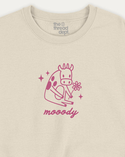 Beige sweatshirt with pink giraffe graphic and 'moody' text on a white background
