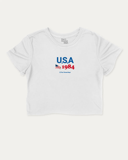 USA 1984 cute and trendy crop tee with nostalgic graphic, perfect for women. A must-have cropped aesthetic shirt, ideal for daily outfits and casual days. White crop tee