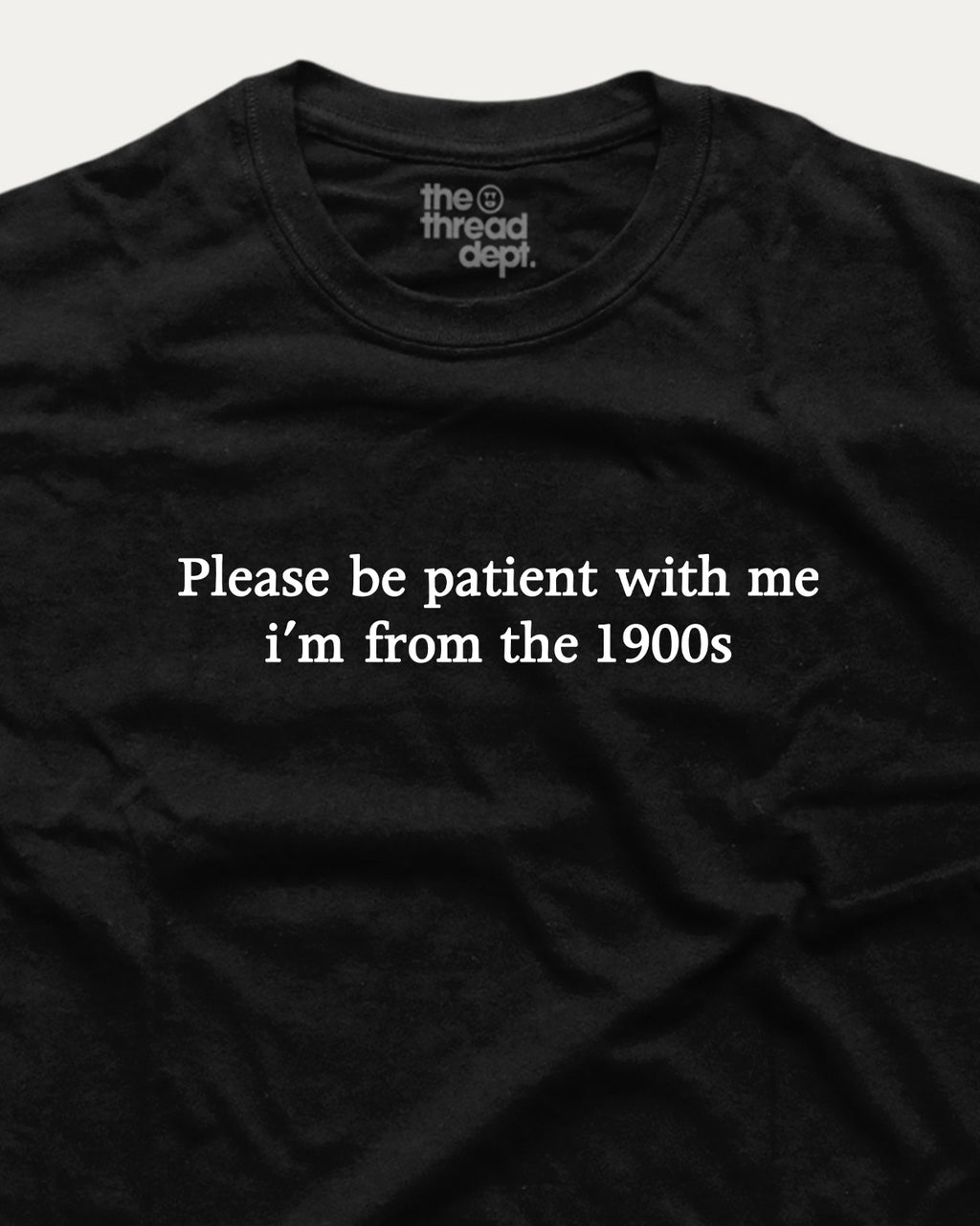 Black t-shirt with white text 'Please be patient with me i'm from the 1900s' and 'the thread dept.' logo.