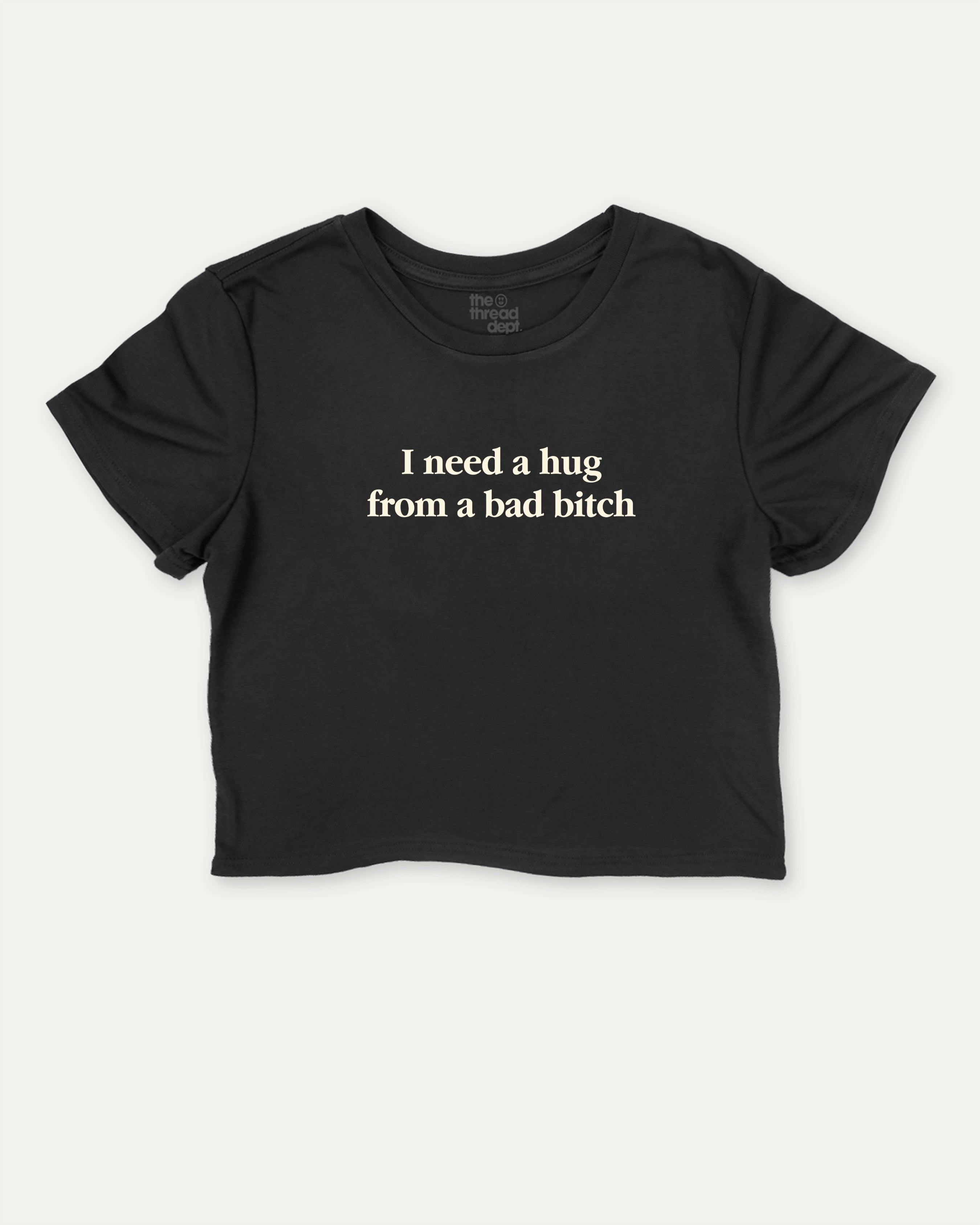 I Need A Hug From A Bad Bitch graphic crop tee with funny and trendy slogan print, perfect for women’s casual looks or layering. Black crop t-shirt.