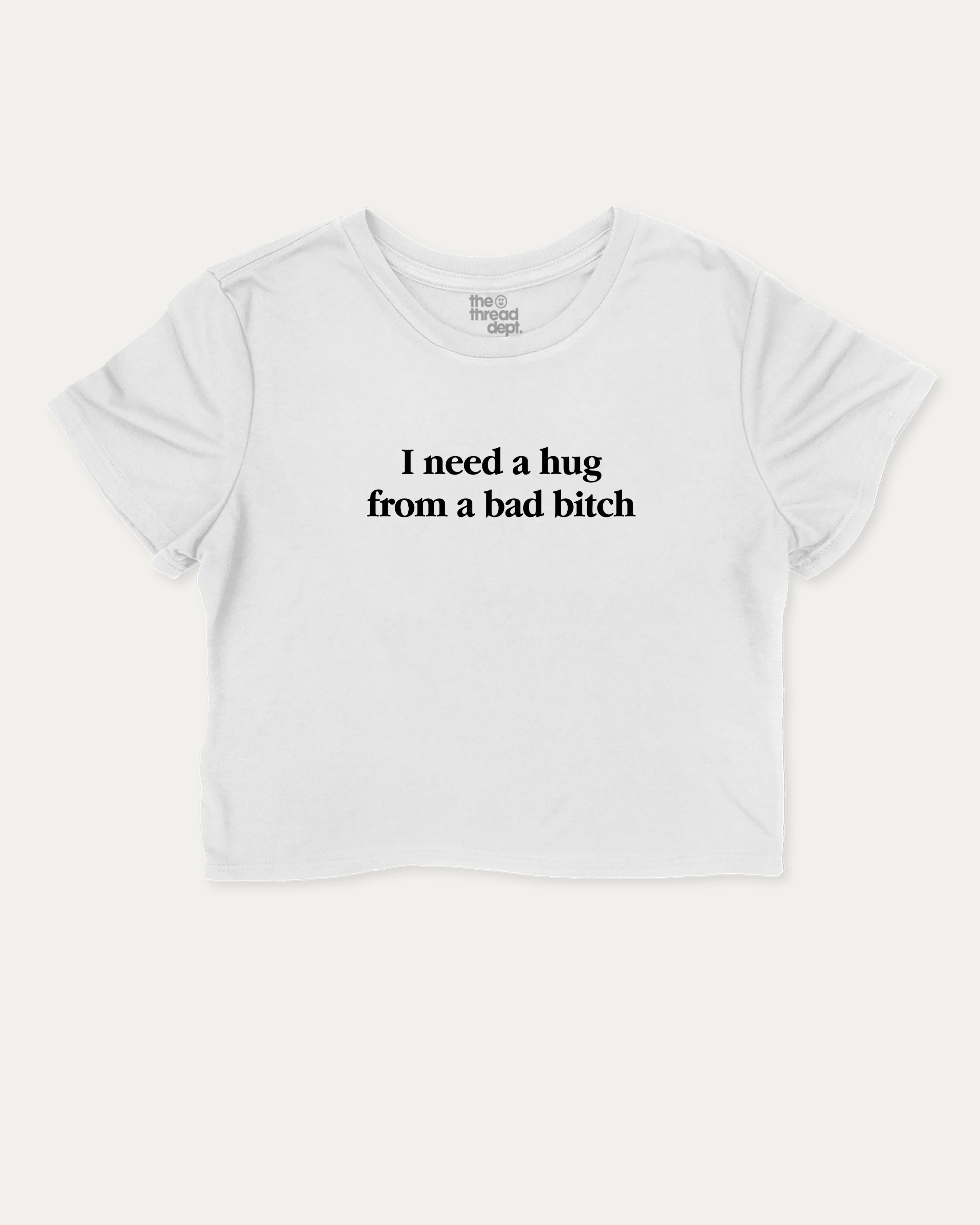 I Need A Hug From A Bad Bitch graphic crop tee with funny and trendy slogan print, perfect for women’s casual looks or layering. White crop t-shirt.