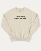 I Need A Hug From A Bad Bitch graphic sweatshirt with bold and funny print, warm and cozy graphic for everyday wear. Perfect for adults and gift-giving. Natural pullover.