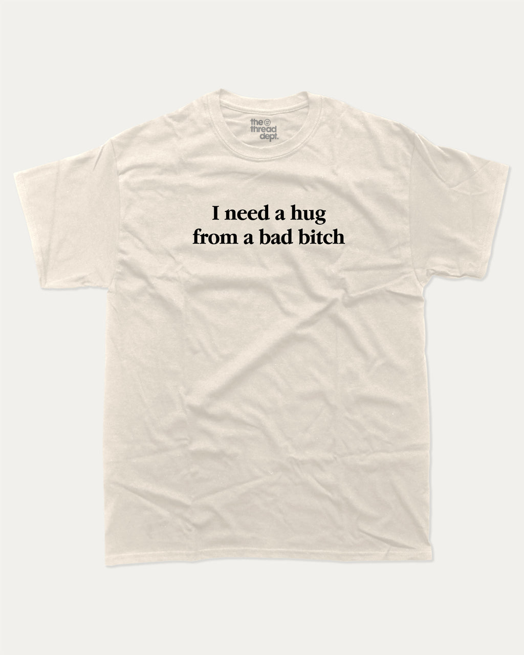 I Need A Hug From A Bad Bitch graphic tee with bold and funny print, funny and trendy graphic. Perfect for adults and gift-giving. Cream shirt.