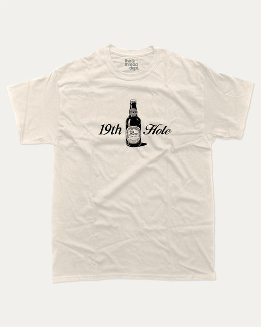 Golf 19th Hole Beer graphic tee with bold and humorous print, funny and trendy graphic. Perfect Gift for Golfers, Golf lovers Graphic T shirt,  Perfect for adults and gift-giving. Cream shirt.