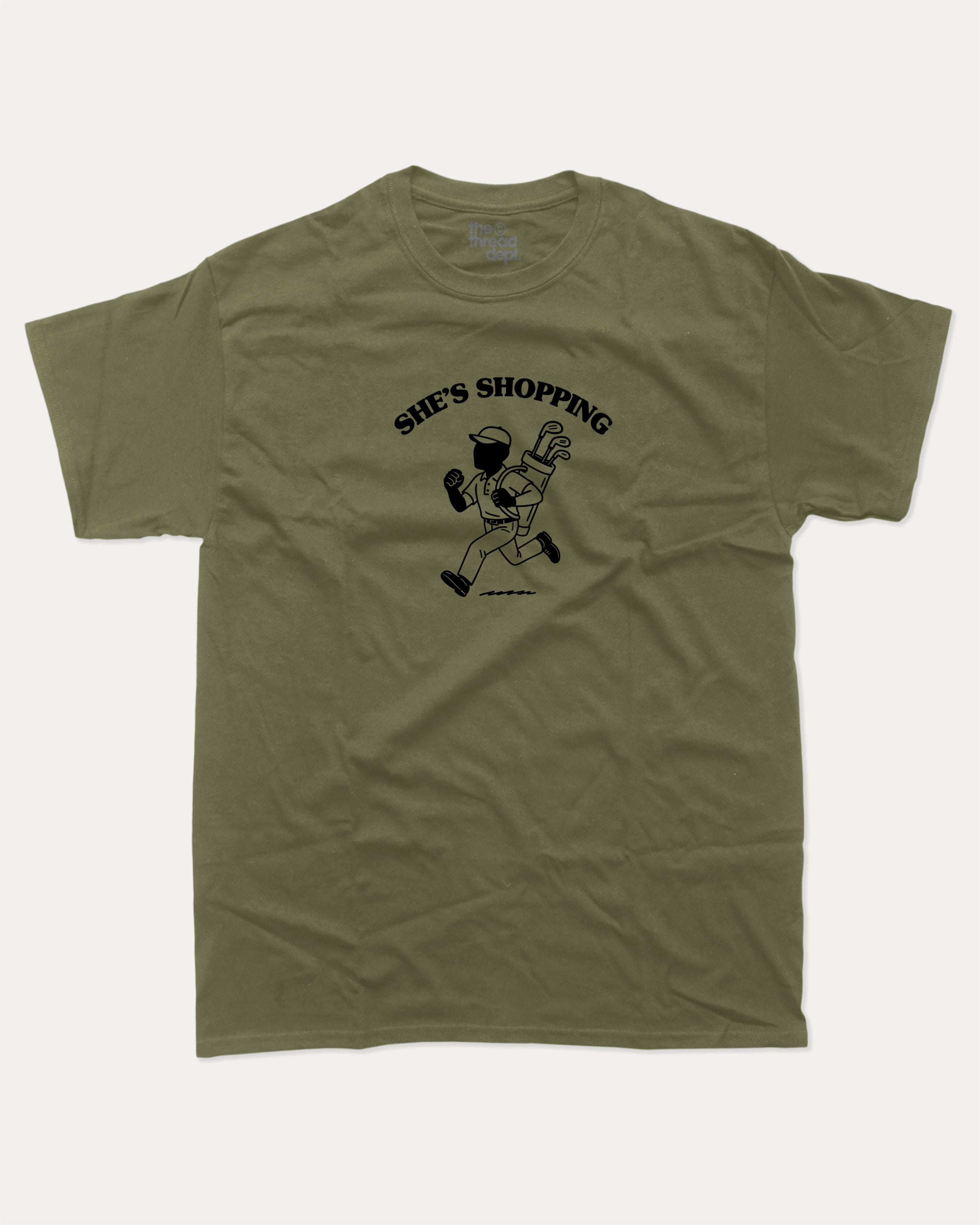 She's Shopping graphic tee with bold and humorous print, Golf Graphic T shirt, Perfect Gift for Golf Lover,  funny and trendy graphic. Perfect for adults and gift-giving. Military Green shirt.