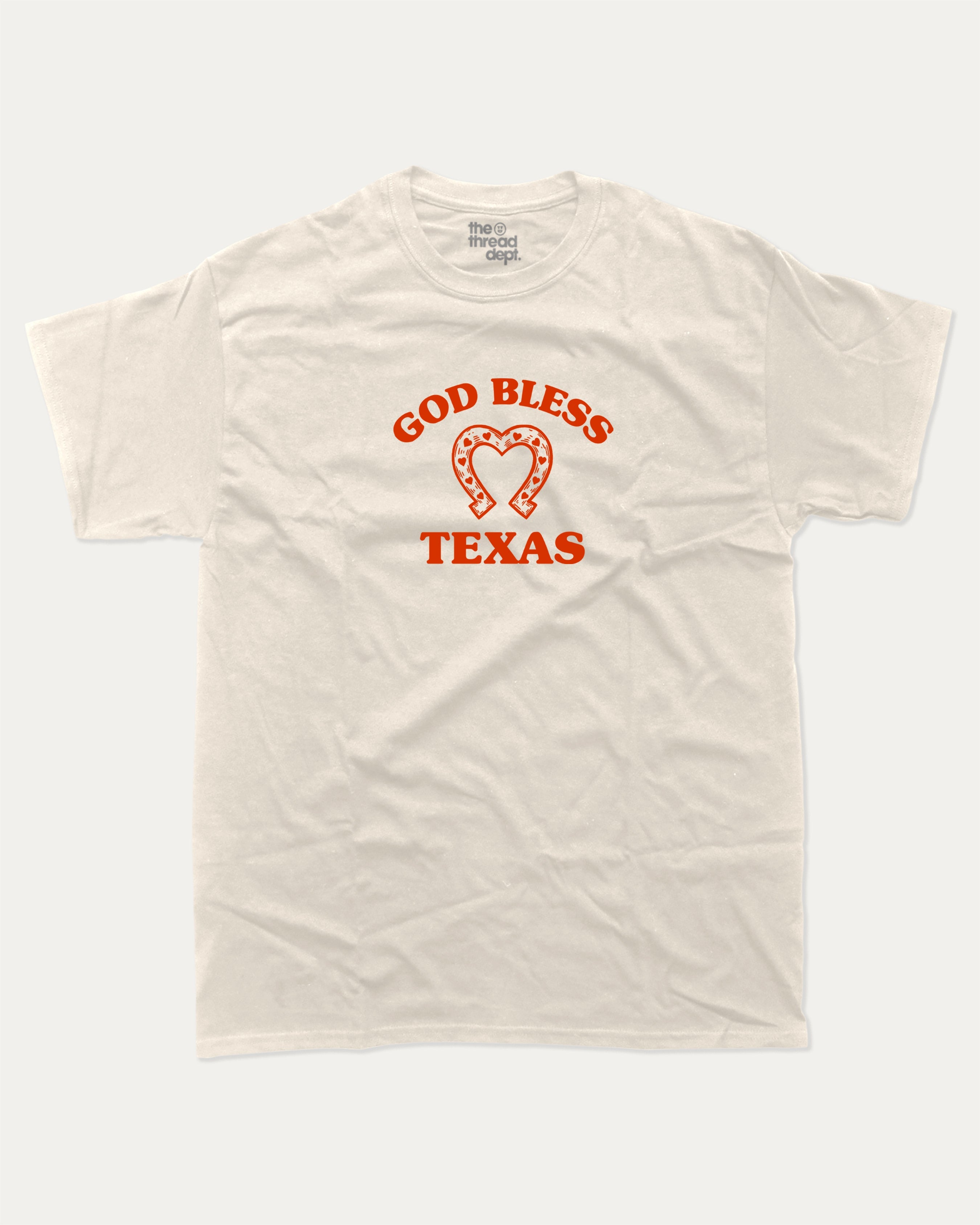God Bless Taxas graphic tee with bold and humorous print, funny and trendy graphic. Perfect for adults and gift-giving. Cream shirt.