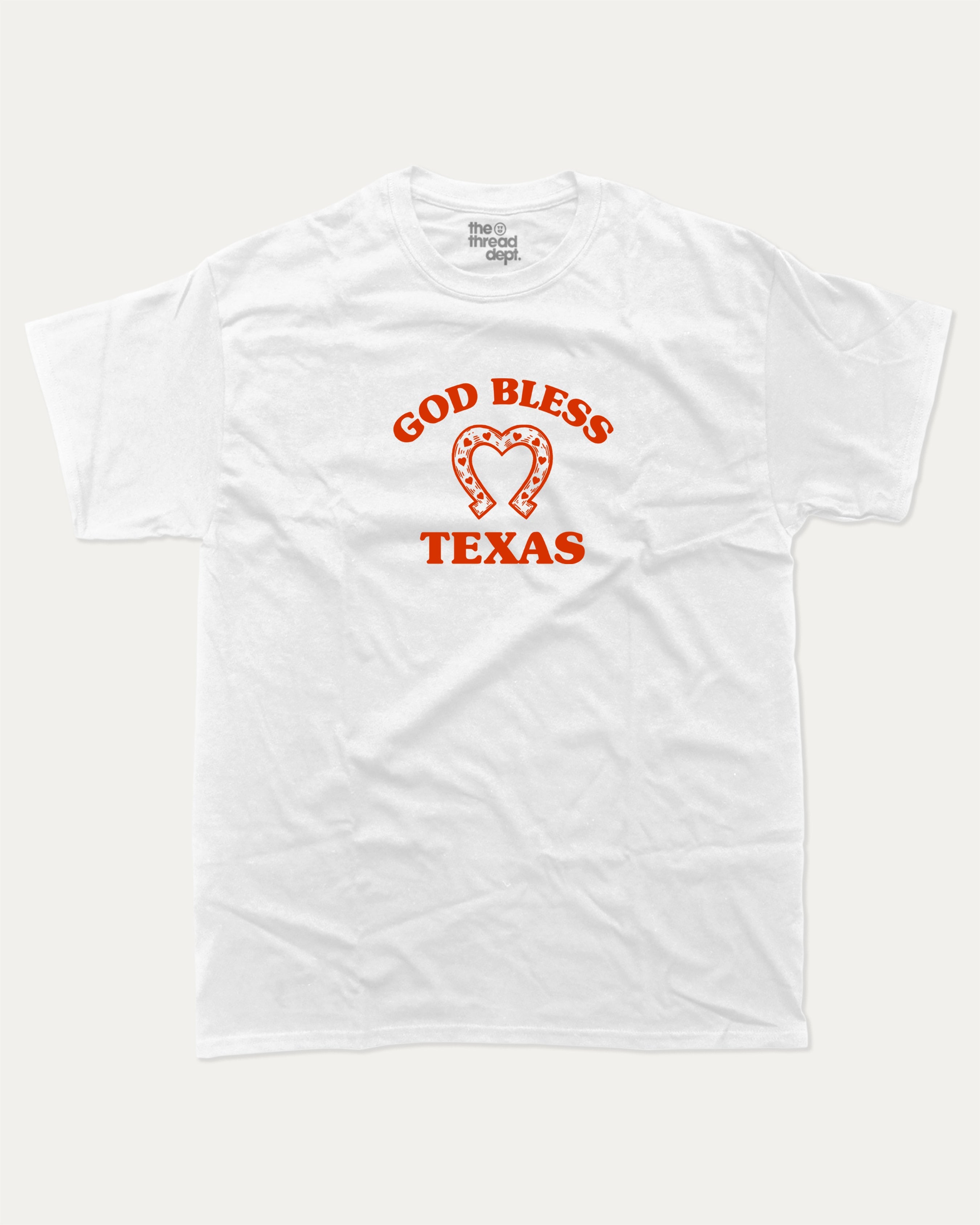 God Bless Taxas graphic tee with bold and humorous print, funny and trendy graphic. Perfect for adults and gift-giving. White shirt.