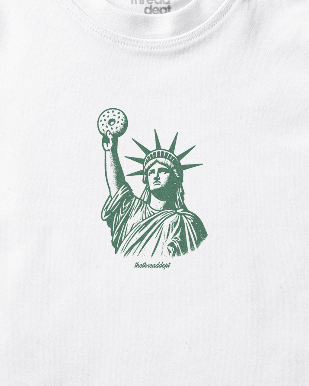 White t-shirt with green Statue of Liberty Bagle graphic on a white background